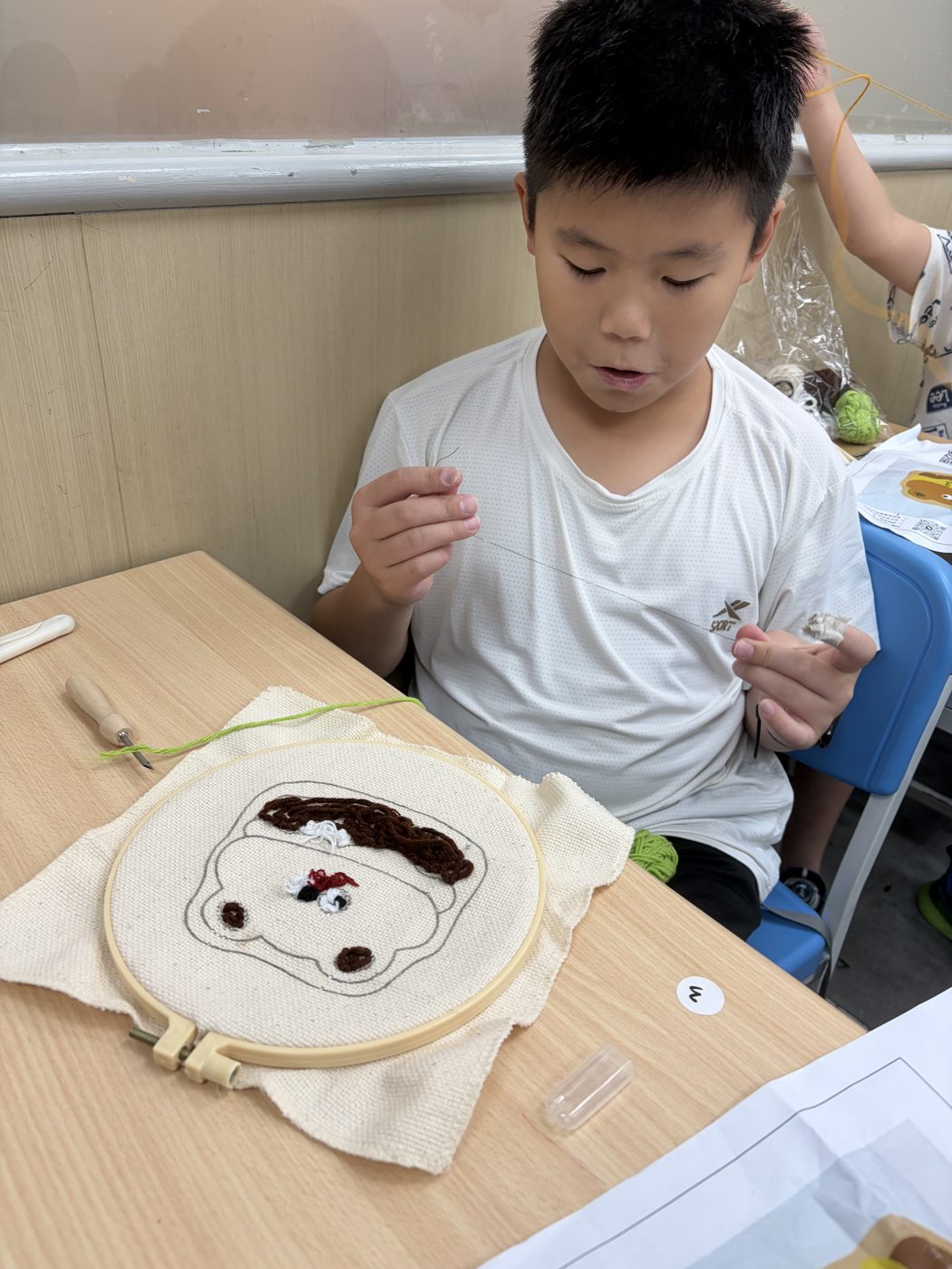 完成刺繡作品的男孩